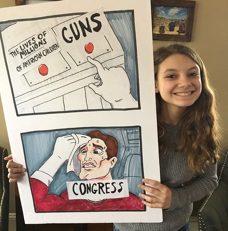 Student-made signs, like the one held by Madelyn Colonna, were made to advocate for change to gun control legislation.