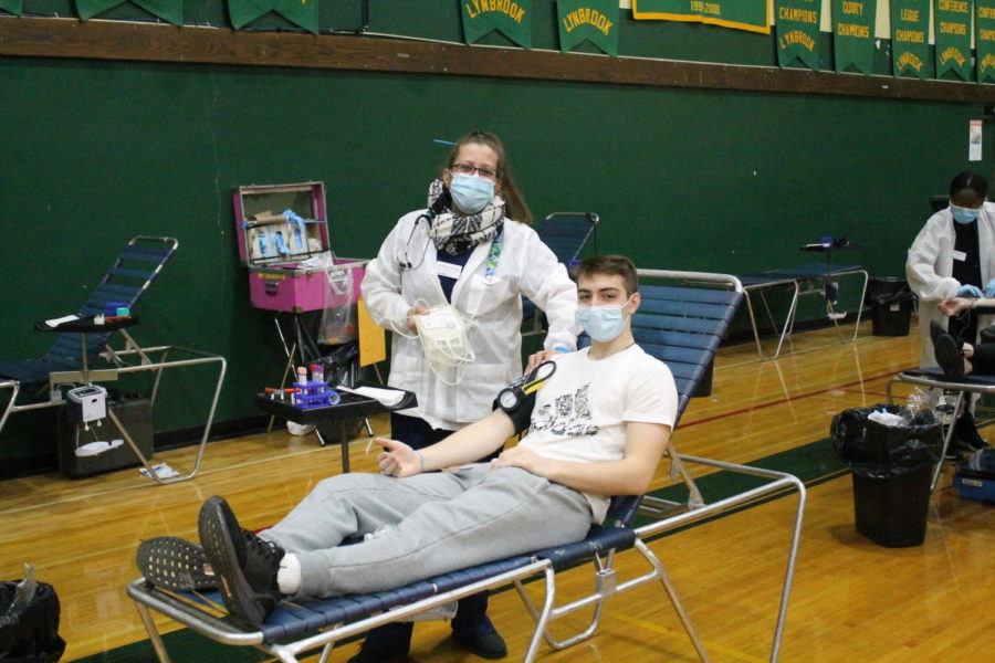 A student gives blood at the LHS Key Club Blood Drive.