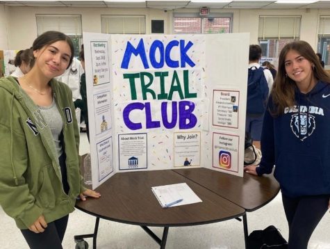 Fucci and Ioannou pose with the Mock Trial Clubs poster at the club fair