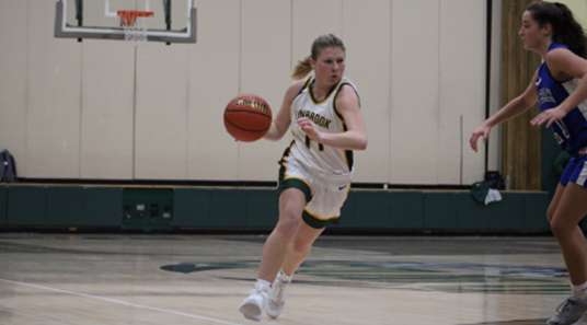 Senior Kaelynn O’Brien driving to the basket against a Marines defender in the second half