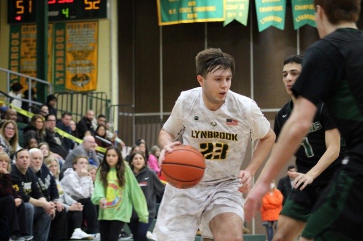 Senior Will Krapf posts up against Spartan defenders late in Lynbrook’s 56-66 loss.