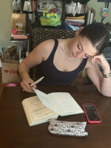 Erin Kelly flips through her notebook. The notebook is filled with songs she has written, as well as poetry she intends on converting into song. On her phone, music plays, setting the mood.