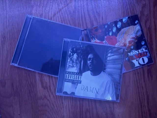 A few music CDs are scattered on the ground. While not as common nowadays, checking out someone’s CD collection was a great way to bond over shared music taste or strike up conversation. Just through shared music taste, strangers could quickly become friends.